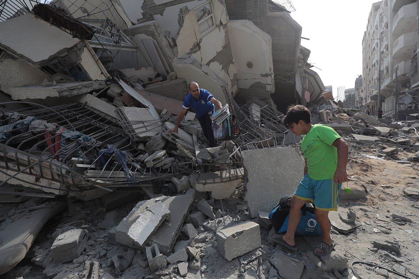 A man and boy stand amongst damage in the Gaza Strip
